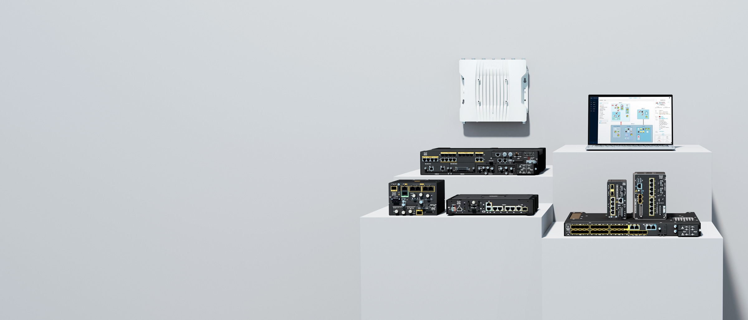 Cisco Industrial IoT routers, switches, access point, and a laptop displaying Cyber Vision