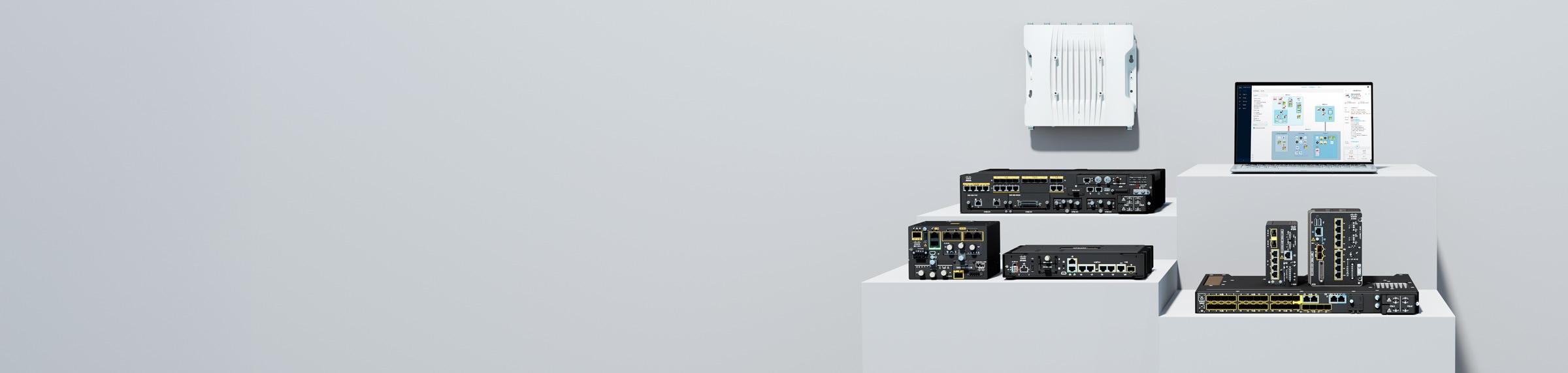 Cisco Industrial IoT routers, switches, access point, and a laptop displaying Cyber Vision