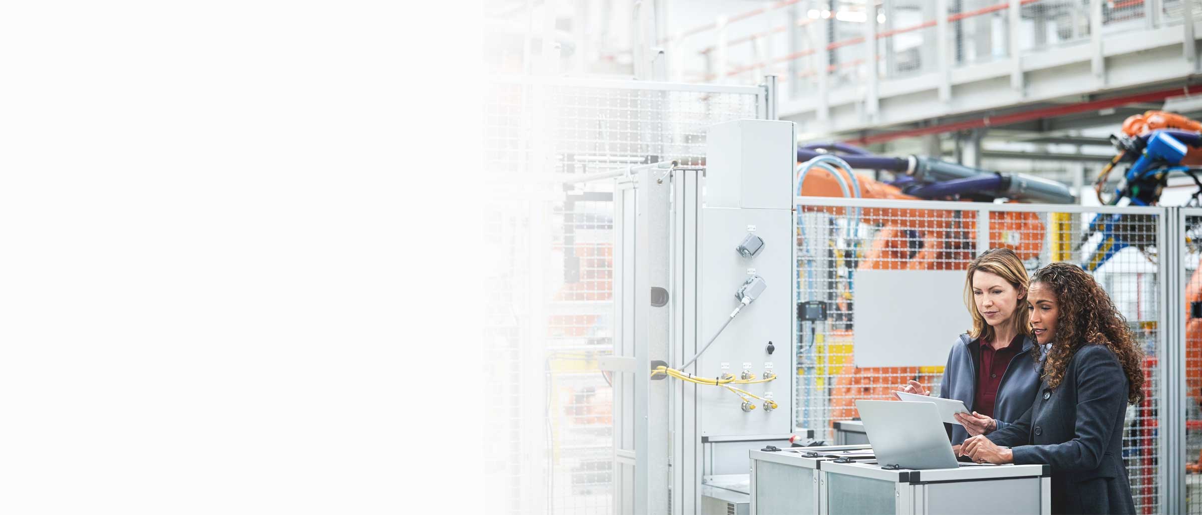 Two manufacturing staff examine data on a device