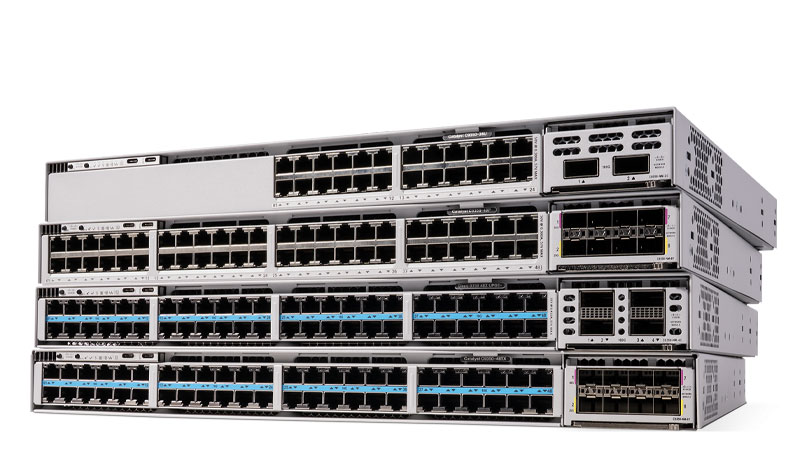 Stack of four Cisco Catalyst network switches with front-facing Ethernet ports and modular uplink bays.