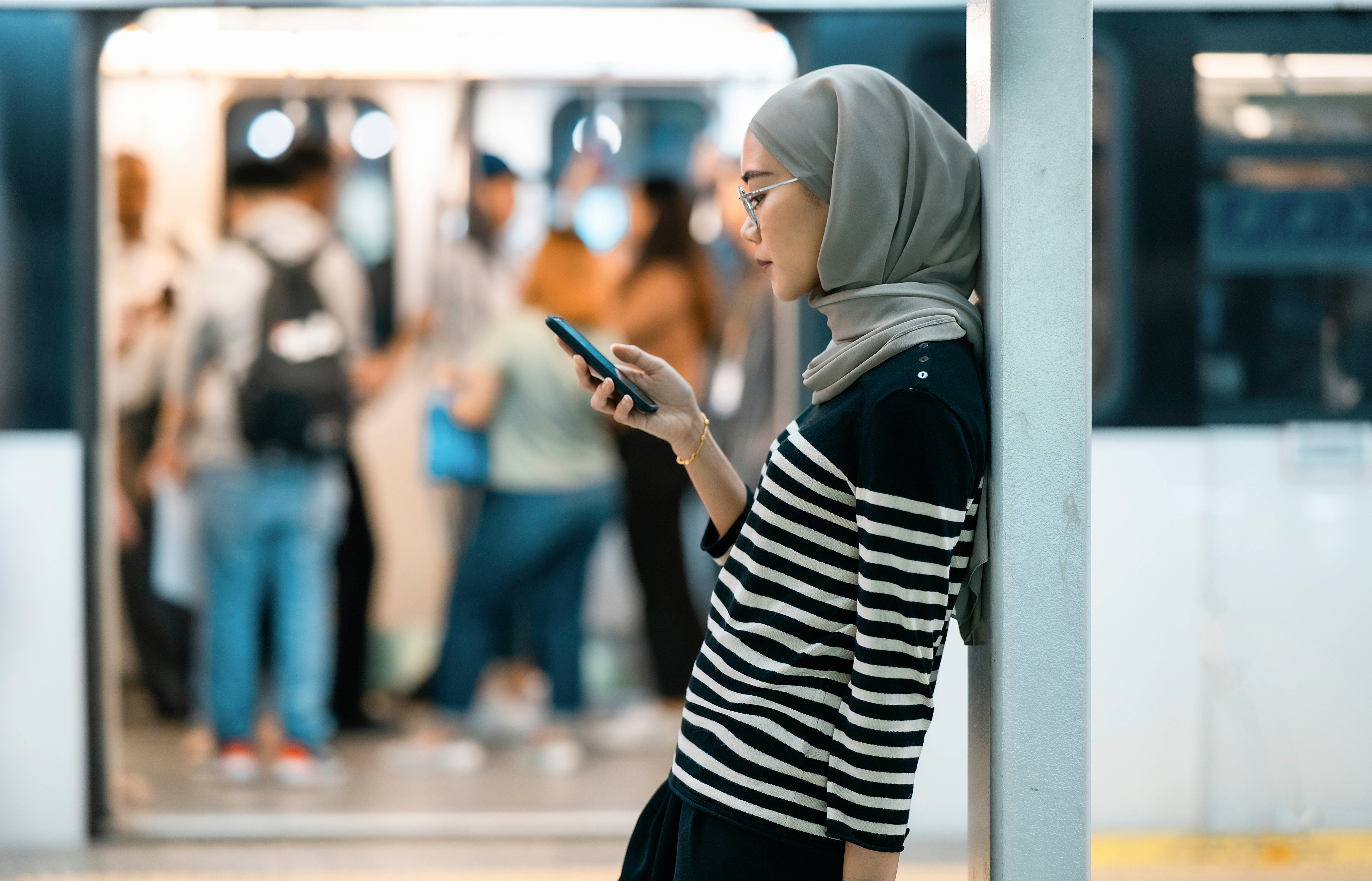 Woman is on phone outside of an open subway car.