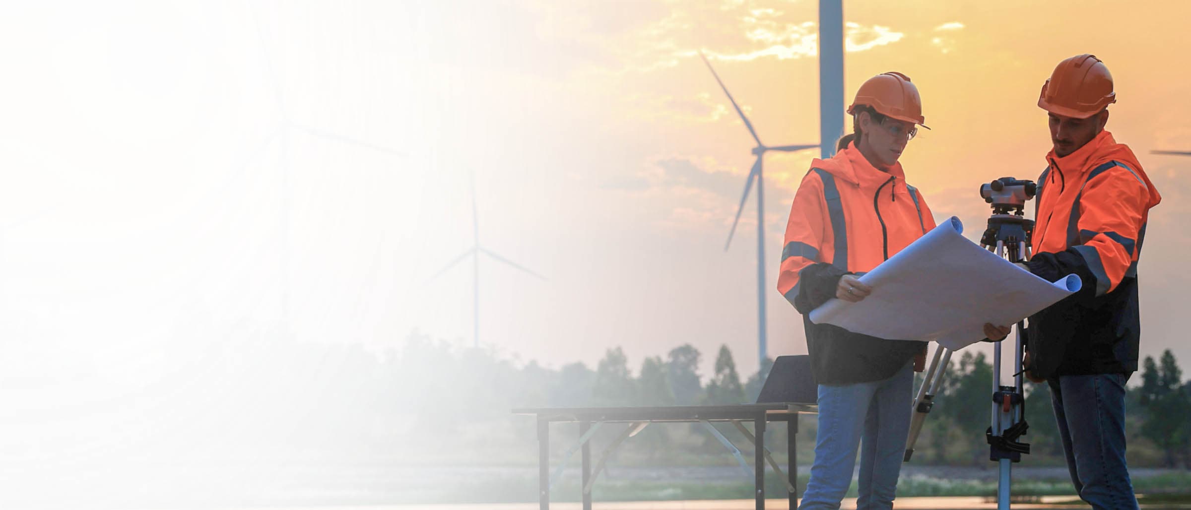 Engineers Reviewing Blueprints at Wind Farm Site